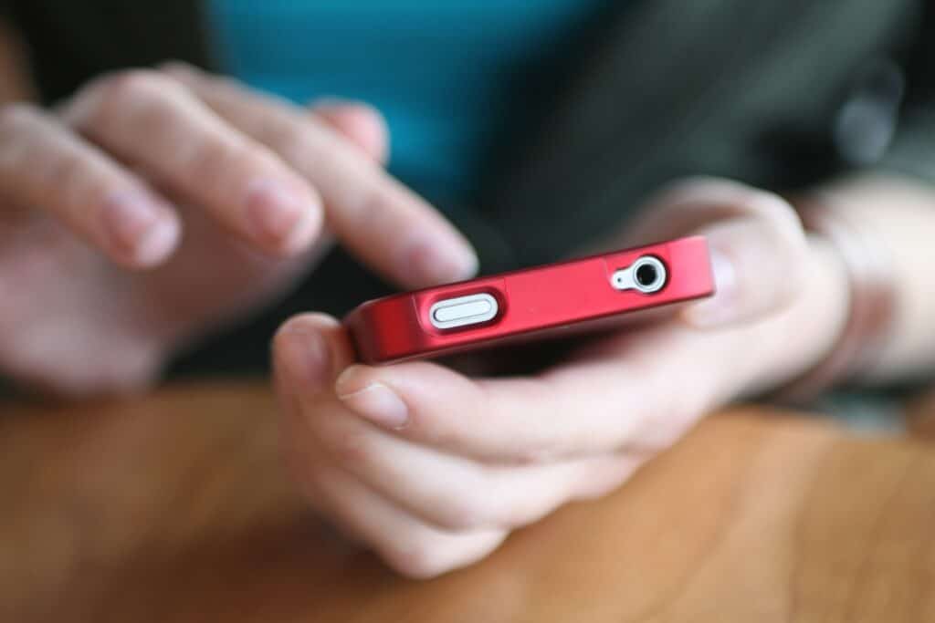 Fotografia de mãos mexendo em celular