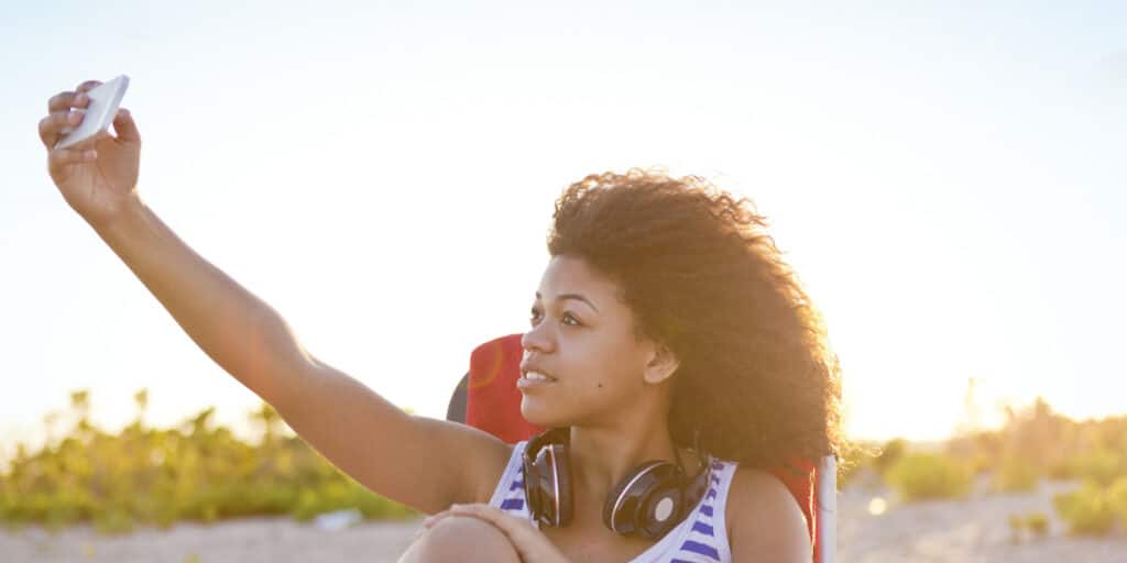 Fotografia de mulher tirando selfie na praia