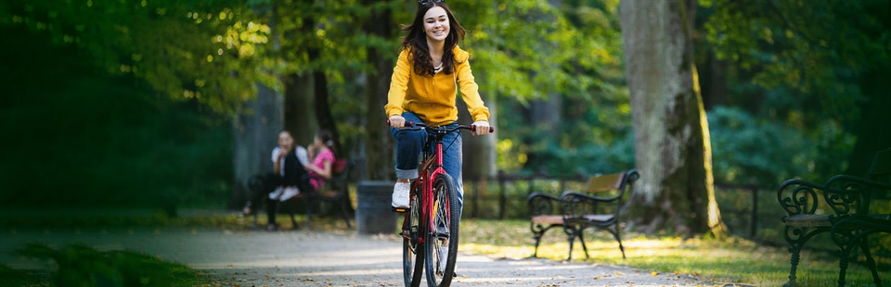 mulher pedalando numa área verde