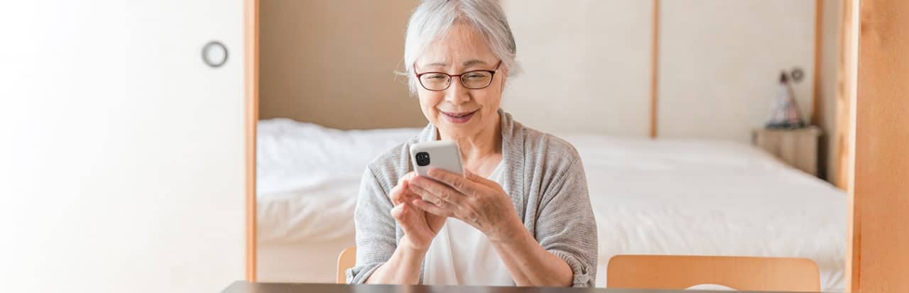 Mãe com smartphone sentada no quarto