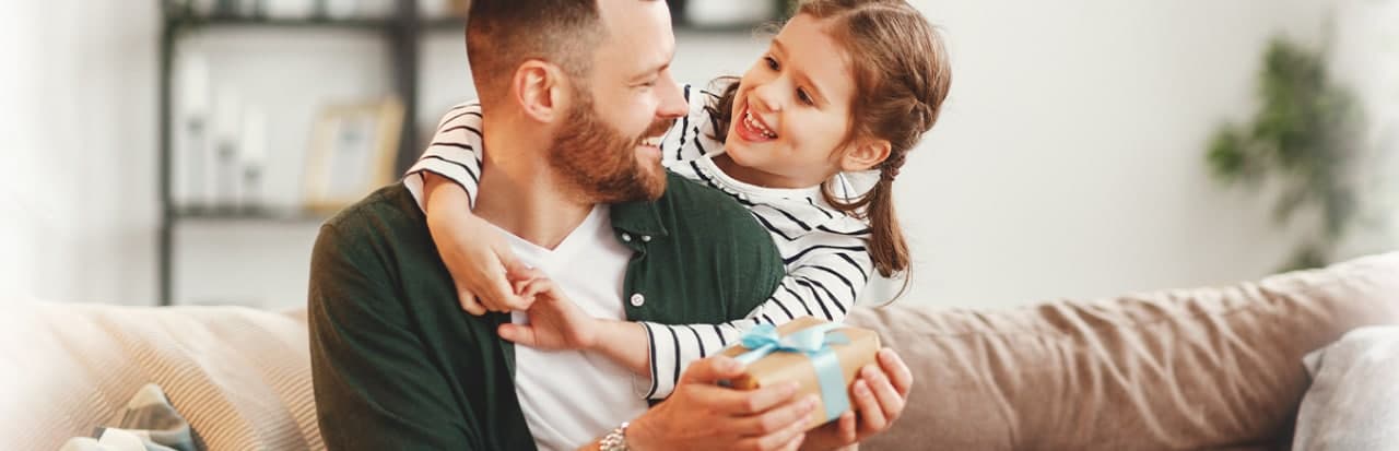 pai e filha abraçados na sala de estar