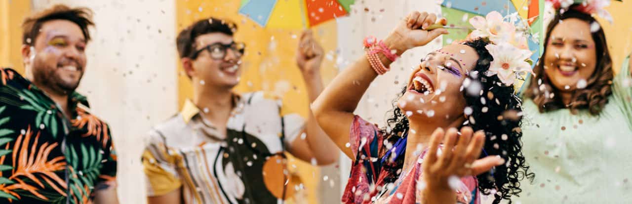 Pessoas curtindo o carnaval bem coloridos, alegres e com serpentinas