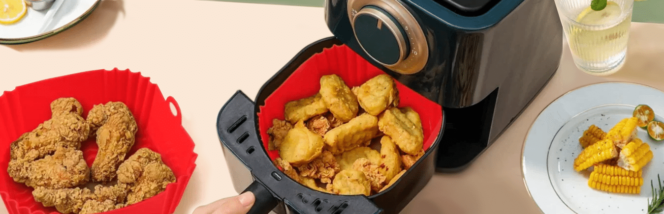 Air Fryer com panela de silicone e comidas sendo preparadas